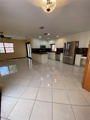 a kitchen with stainless steel appliances granite countertop a refrigerator and a stove top oven