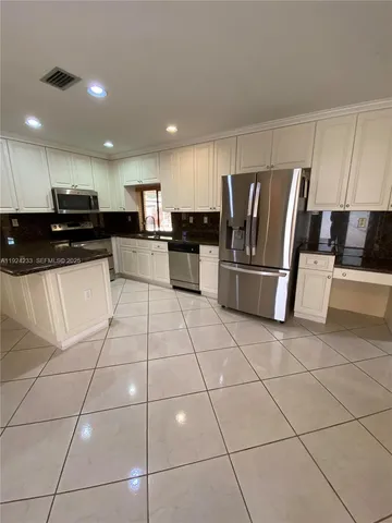 a kitchen with stainless steel appliances a refrigerator sink and microwave