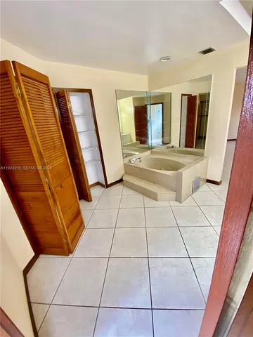 a large white kitchen with a sink and cabinets