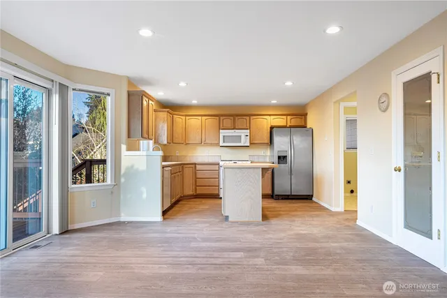 a large kitchen with a large window and stainless steel appliances