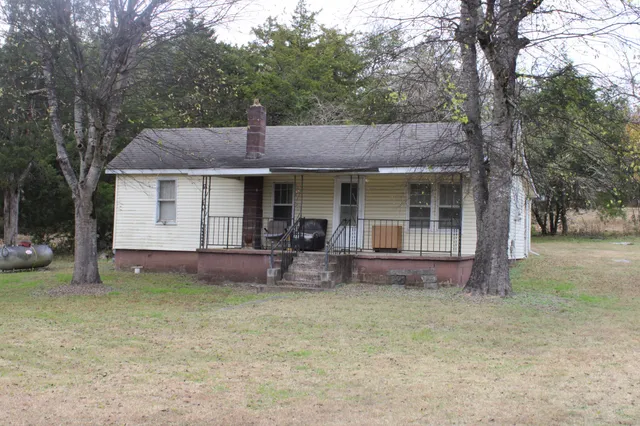 a front view of a house with yard and trees