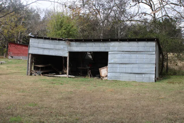 a view of a house with a yard and a large tree