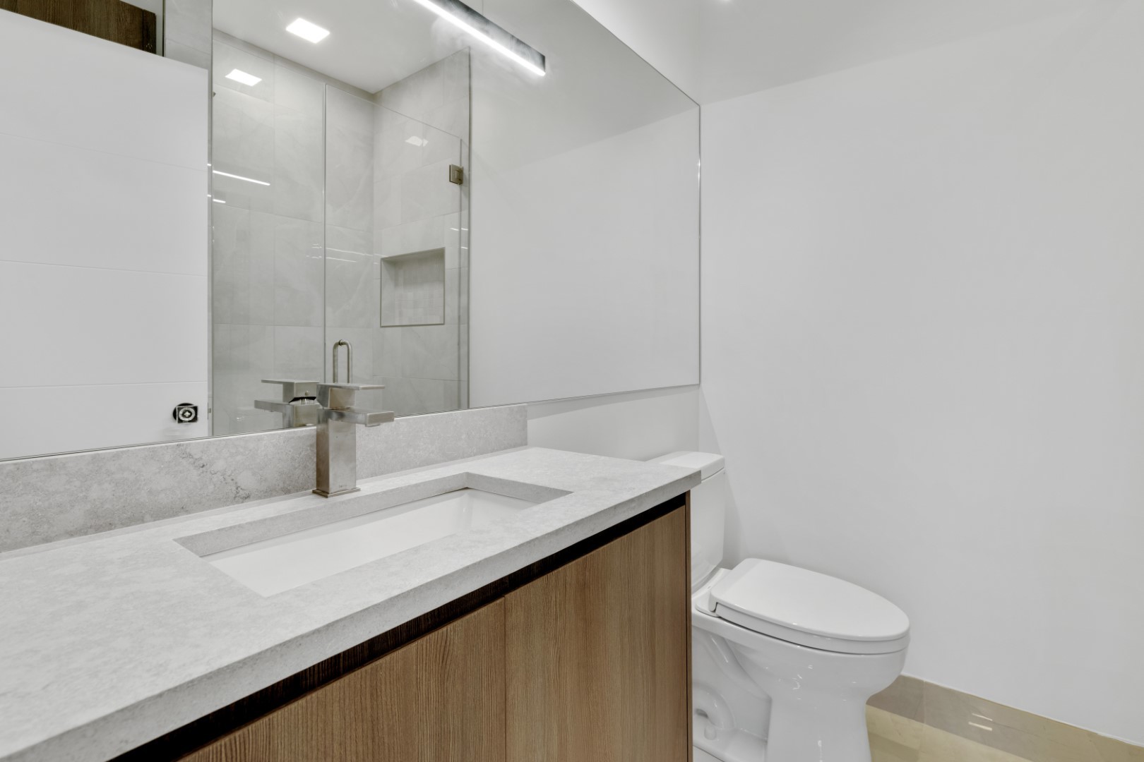 334 East Pershing Road Chicago, IL 60653 - Photo 67 of 86 a bathroom with a granite countertop sink a toilet and a mirror