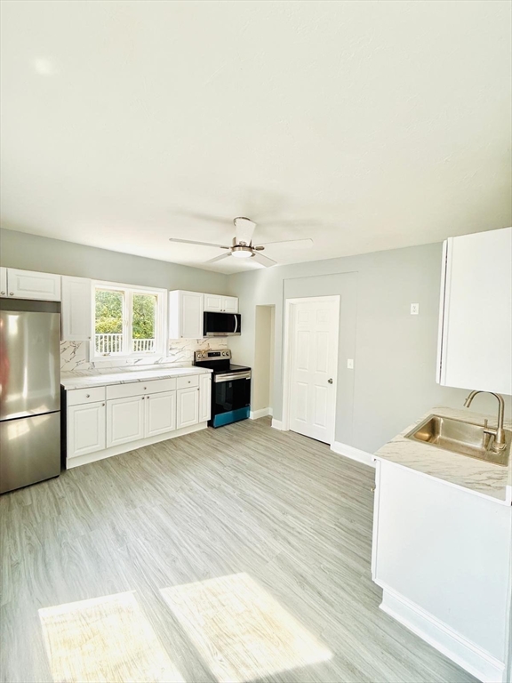 154 Marshall Street, Unit 2 Fitchburg, MA 01420 - Photo 3 of 9 a kitchen with a stove a sink and a refrigerator