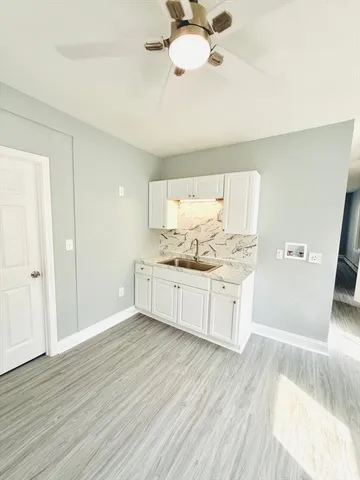 a kitchen with stainless steel appliances kitchen island granite countertop a sink cabinets and wooden floor