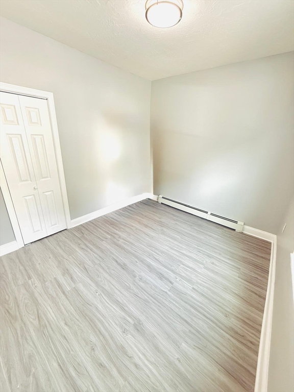 154 Marshall Street, Unit 2 Fitchburg, MA 01420 - Photo 5 of 9 a view of an empty room with wooden floor