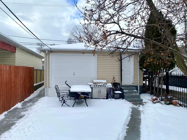 a view of a patio with table and chairs and wooden fence