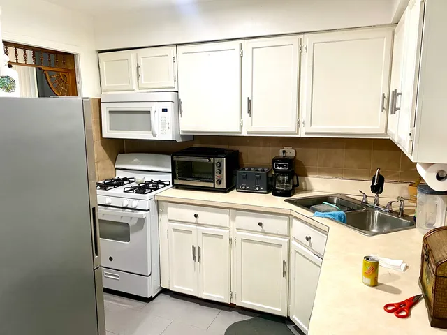 a kitchen with white cabinets and white appliances