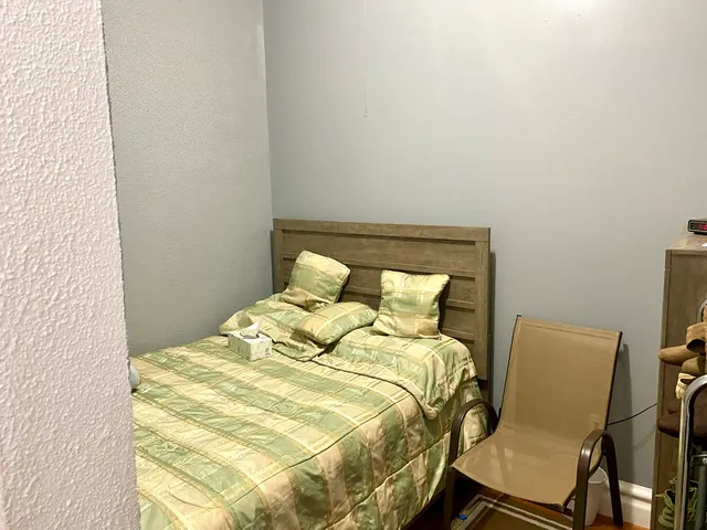 a bed sitting in a bedroom next to a window