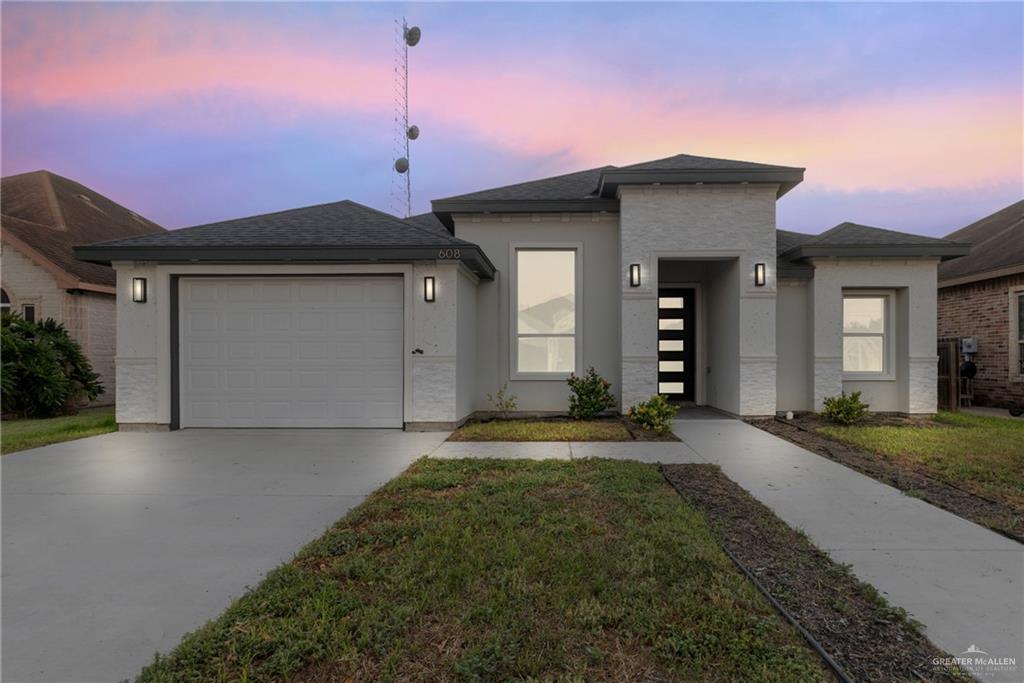 a front view of a house with a yard and garage