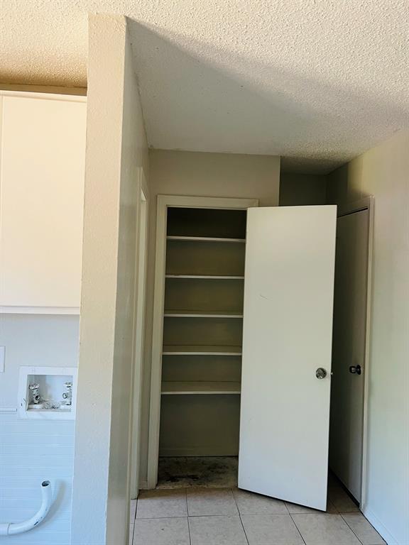 6320 Midway Road, Unit C Springtown, TX 76082 - Photo 5 of 11 Utility area featuring a multi-shelf pantry, tile flooring, and dedicated laundry hookups