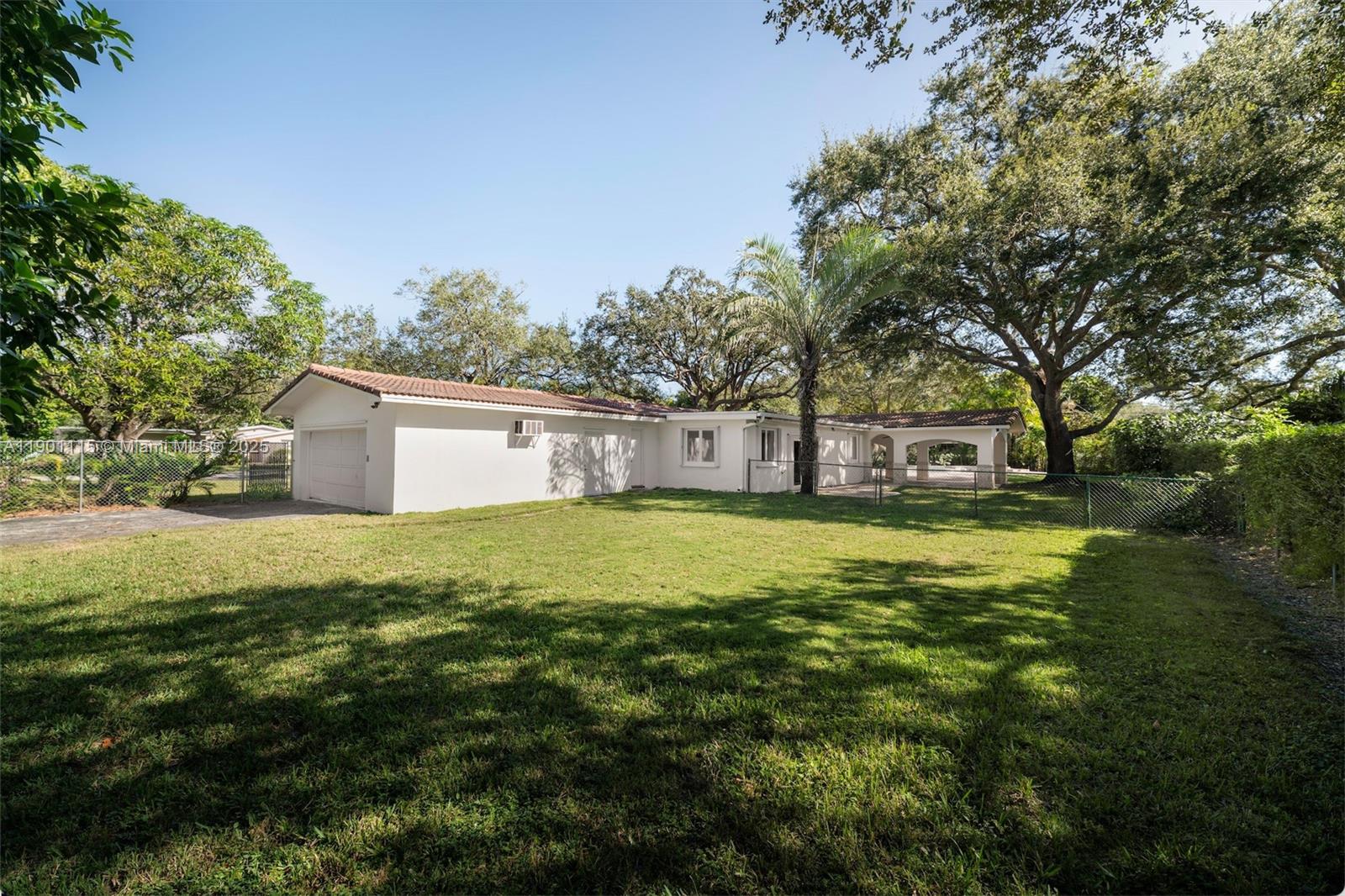 8390 Southwest 132nd Street Pinecrest, FL 33156 - Photo 9 of 12 a front view of a house with yard and green space