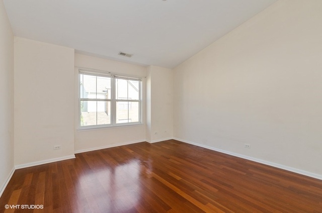 6128 Washington Court Morton Grove, IL 60053 - Photo 5 of 11 an empty room with wooden floor and windows
