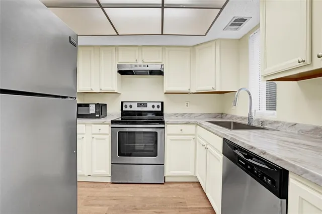 a kitchen with granite countertop white cabinets and a stove