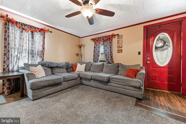 a living room with furniture a chandelier and a large window