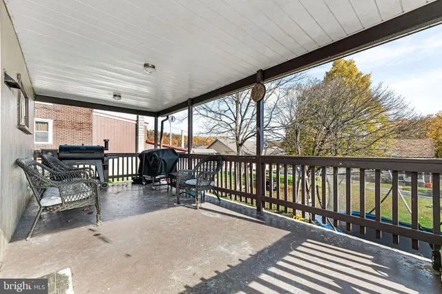a balcony with chairs and wooden fence