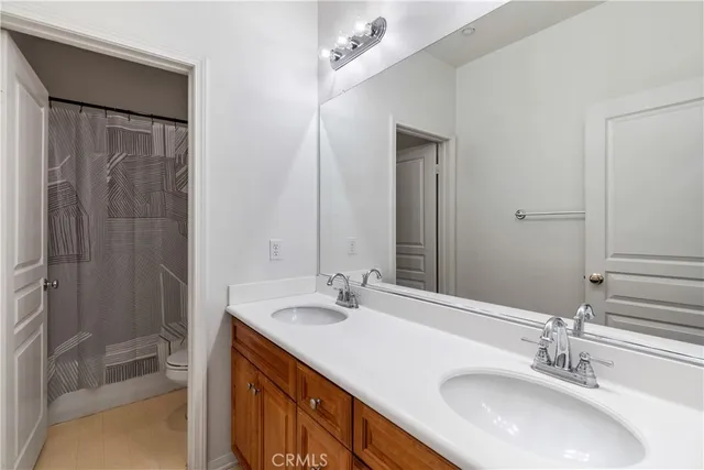 a bathroom with double vanity sink and a mirror