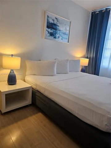 a bedroom with a bed and lamp on table