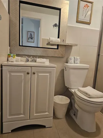 a bathroom with a granite countertop toilet sink and mirror