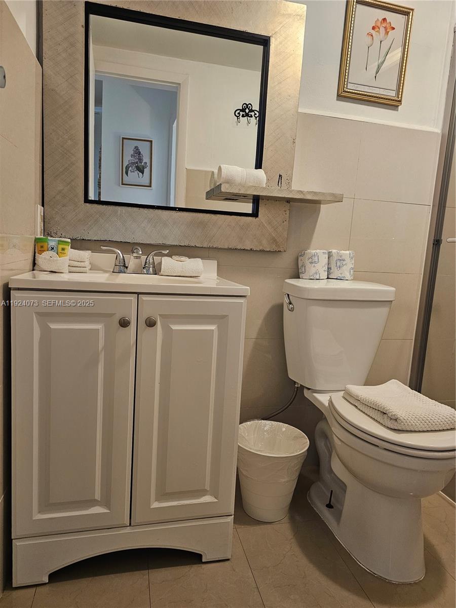 750 Collins Avenue, Unit 201 Miami Beach, FL 33139 - Photo 22 of 39 a bathroom with a granite countertop toilet sink and mirror