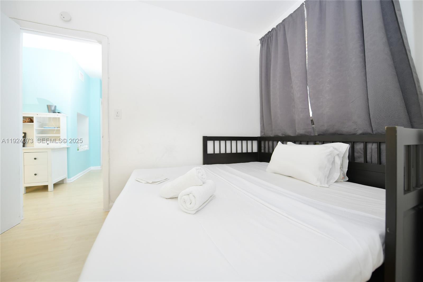 750 Collins Avenue, Unit 201 Miami Beach, FL 33139 - Photo 29 of 39 a bedroom with a bed and a night stand