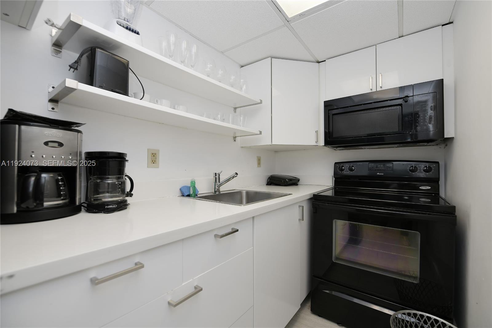 750 Collins Avenue, Unit 201 Miami Beach, FL 33139 - Photo 36 of 39 a kitchen with a stove and a microwave