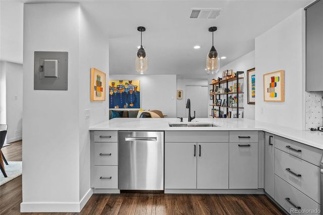 a kitchen with white cabinets and sink