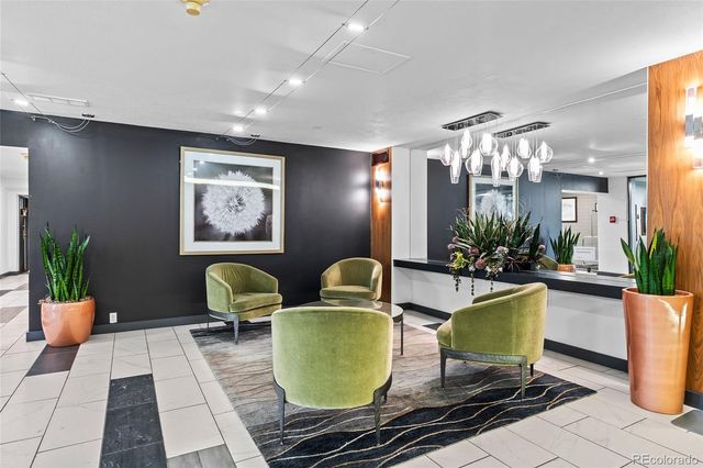 a living room with lots of potted plants and a dining table