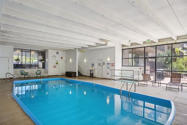 a living room with kitchen island granite countertop furniture a rug and white walls