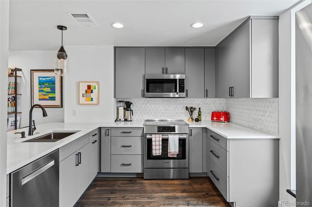 a kitchen with a sink stove top oven and refrigerator