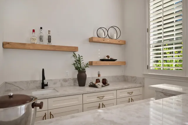 a view of a patio with couches plants and large trees
