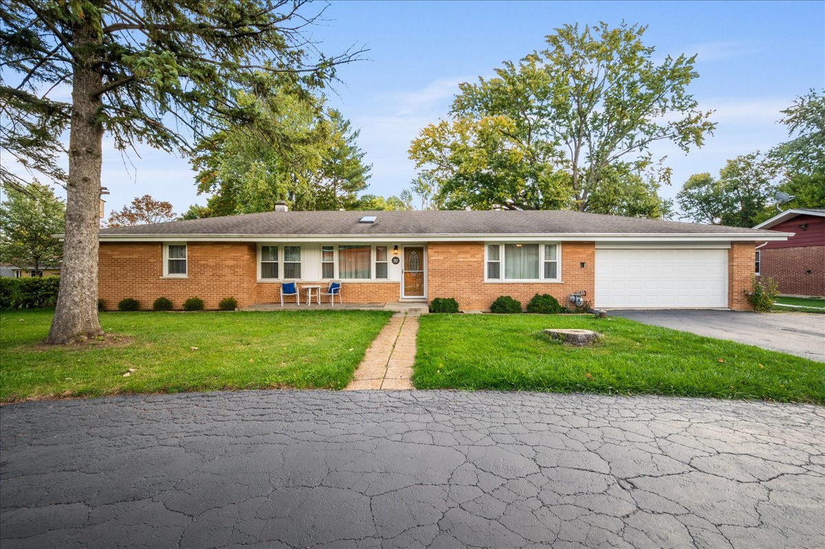 a front view of a house with a yard and trees