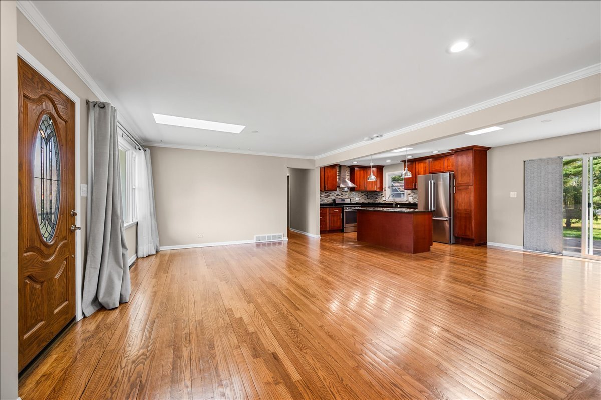 203 Coldren Drive Prospect Heights, IL 60070 - Photo 6 of 31 a view of a big room with wooden floor and windows