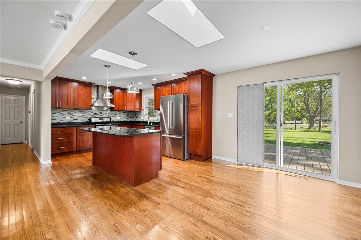 203 Coldren Drive Prospect Heights, IL 60070 - Photo 7 of 31 a kitchen with stainless steel appliances granite countertop a refrigerator a sink a stove and wooden floors