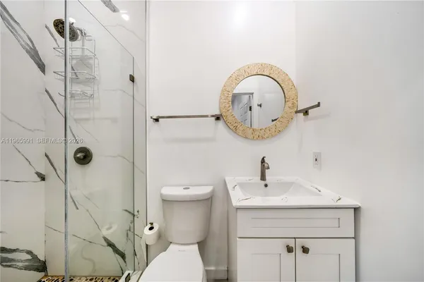 a bathroom with a sink a toilet and a mirror