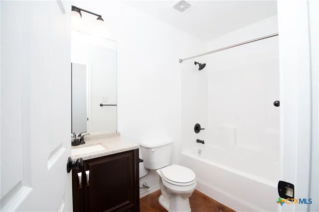 a bathroom with a granite countertop sink toilet mirror and shower