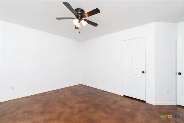 an empty room with a window and a ceiling fan