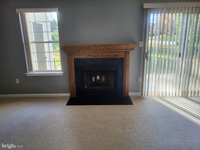 an empty room with fireplace and windows