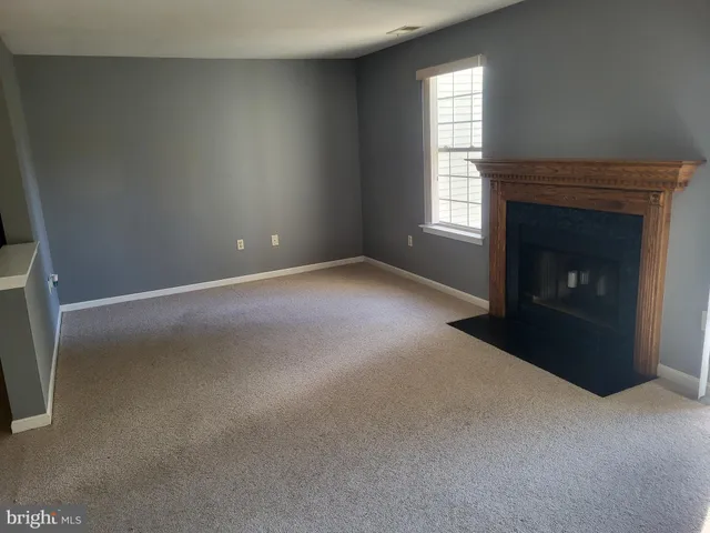 a view of empty room with a fireplace