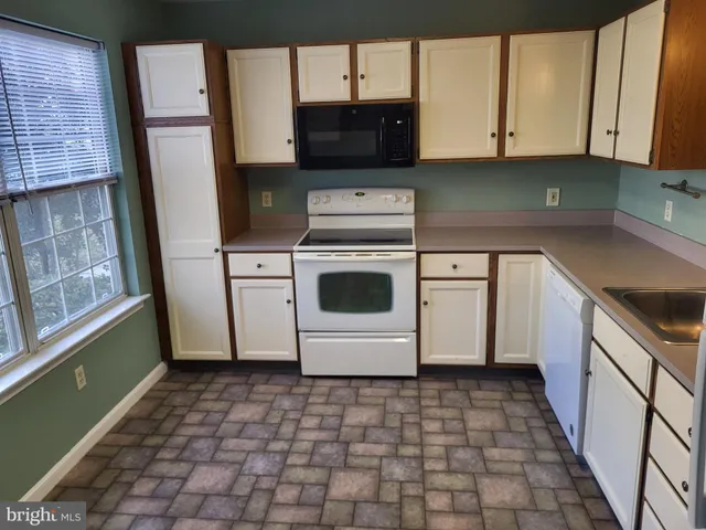 a kitchen with appliances cabinets and a sink