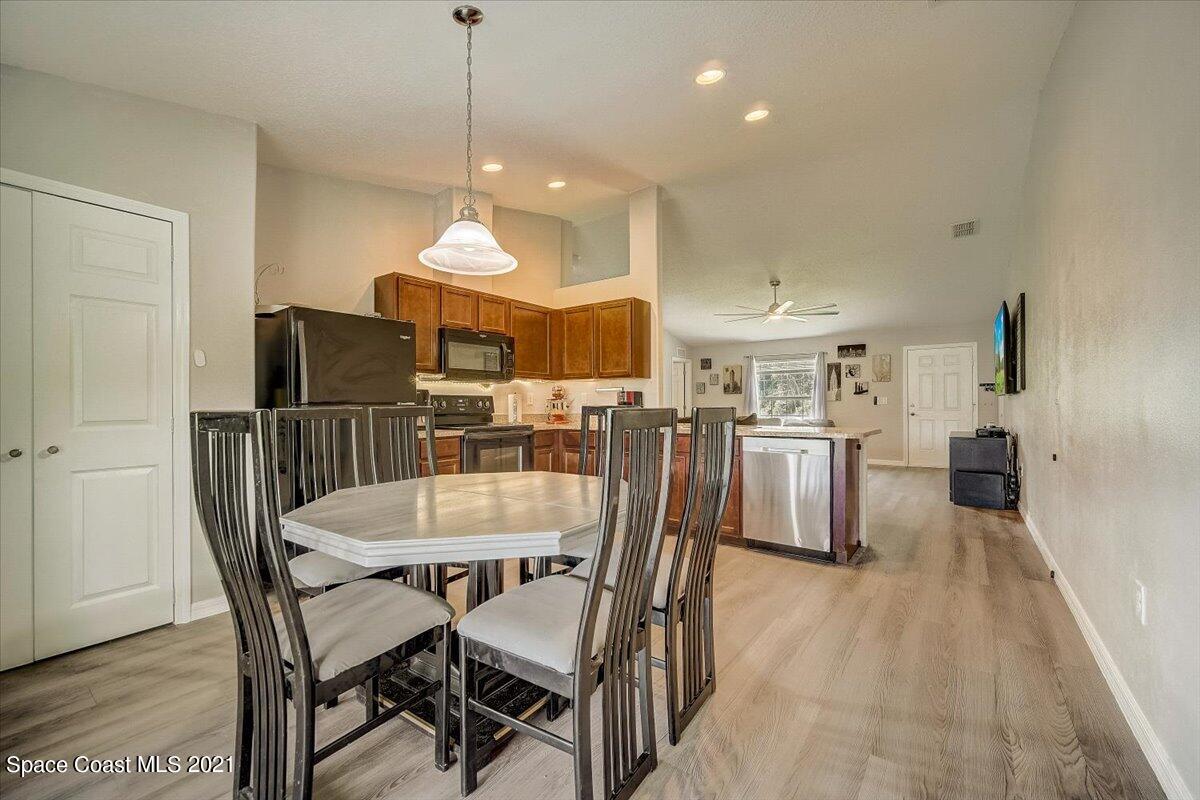 1459 Saxony Road Southwest Palm Bay, FL 32908 - Photo 11 of 38 a dining room with furniture and wooden floor