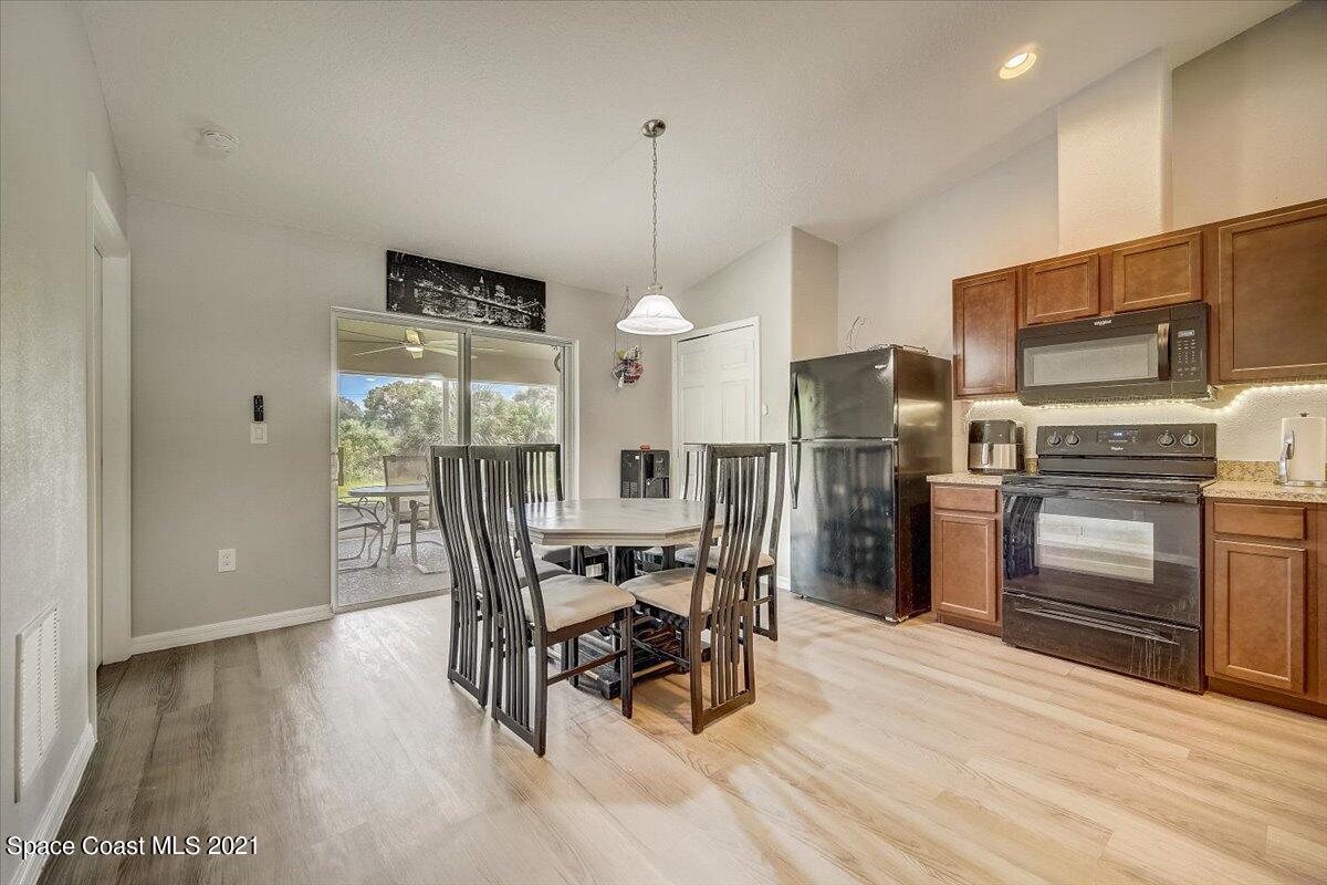 1459 Saxony Road Southwest Palm Bay, FL 32908 - Photo 13 of 38 a view of a dining room with furniture window and wooden floor