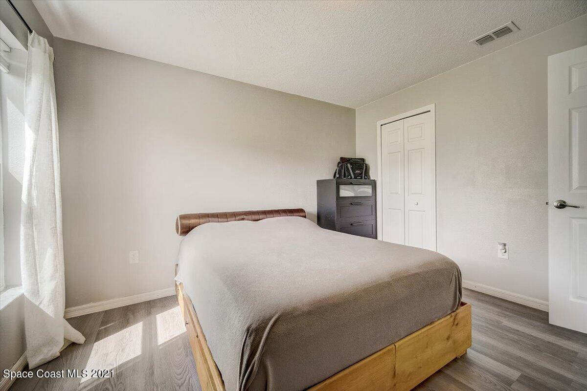 1459 Saxony Road Southwest Palm Bay, FL 32908 - Photo 18 of 38 a bedroom with a bed and wooden floor