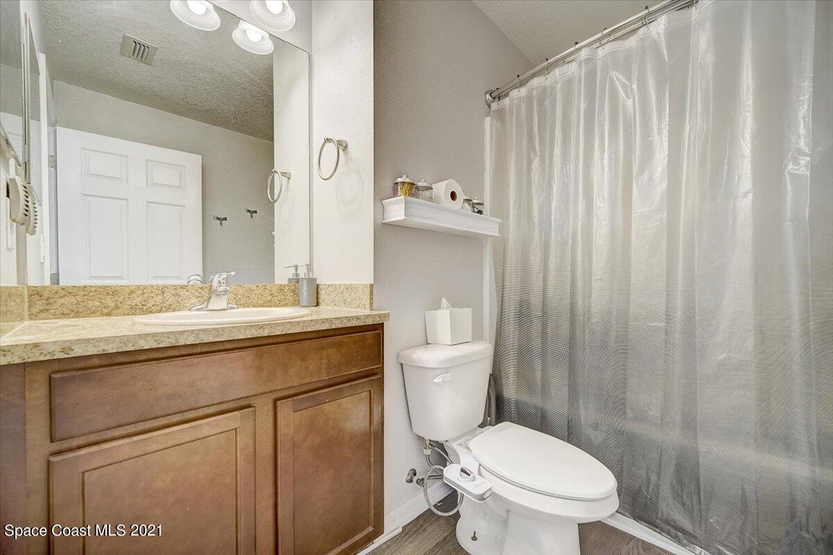 1459 Saxony Road Southwest Palm Bay, FL 32908 - Photo 19 of 38 a bathroom with a granite countertop toilet sink and mirror