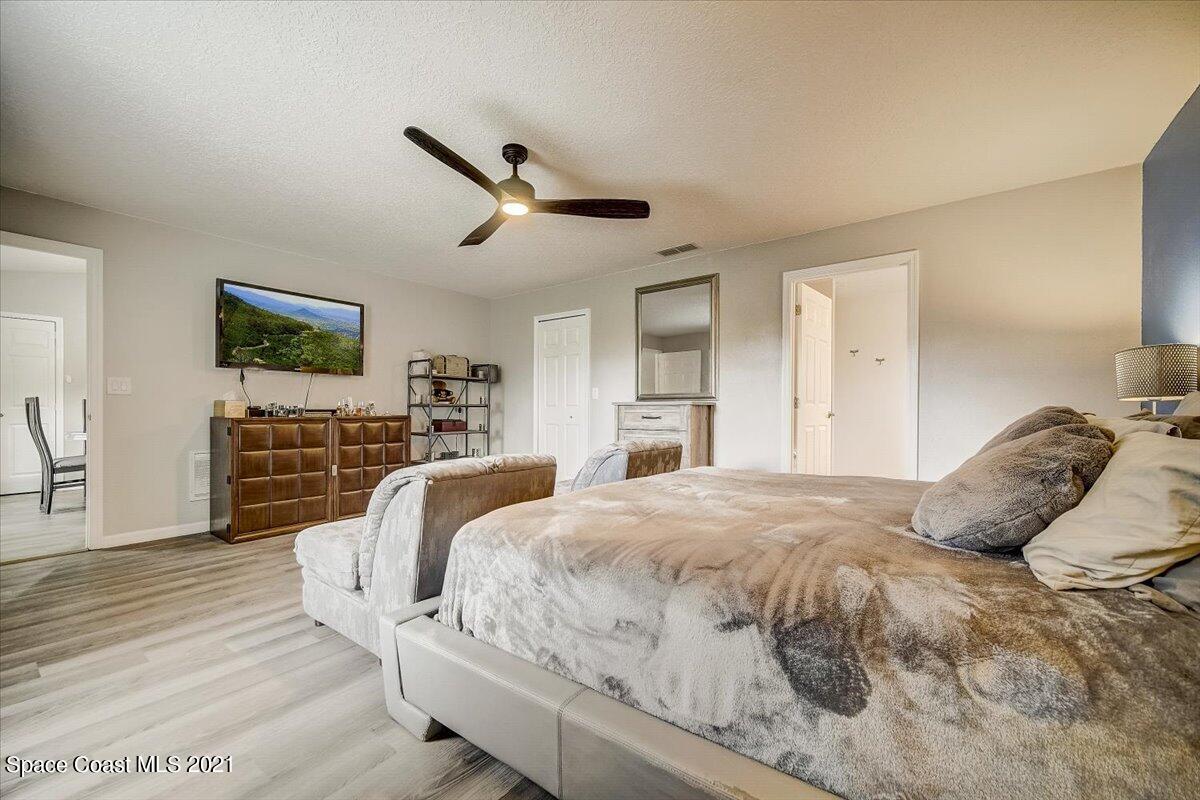 1459 Saxony Road Southwest Palm Bay, FL 32908 - Photo 26 of 38 a bedroom with a large bed and a tv