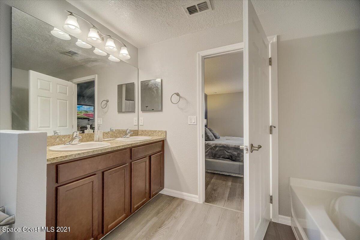 1459 Saxony Road Southwest Palm Bay, FL 32908 - Photo 29 of 38 a bathroom with a granite countertop sink and a mirror