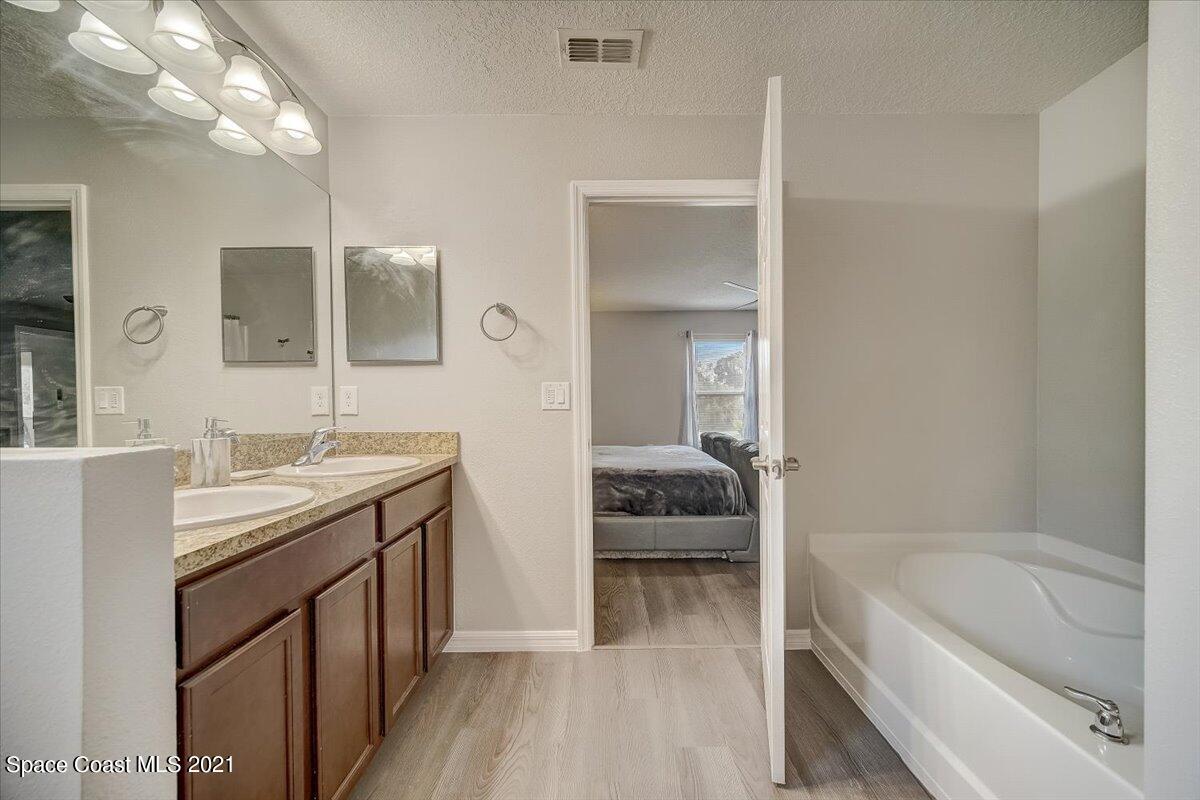 1459 Saxony Road Southwest Palm Bay, FL 32908 - Photo 30 of 38 a en suite bathroom with a tub sink and mirror