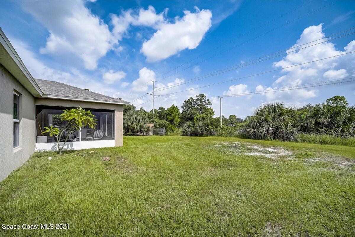 1459 Saxony Road Southwest Palm Bay, FL 32908 - Photo 38 of 38 a view of a house with a big yard and a large tree