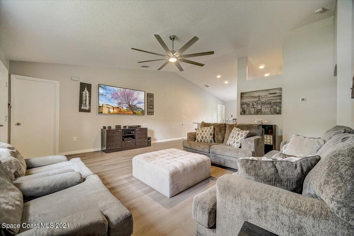 1459 Saxony Road Southwest Palm Bay, FL 32908 - Photo 6 of 38 a living room with furniture and wall paintings