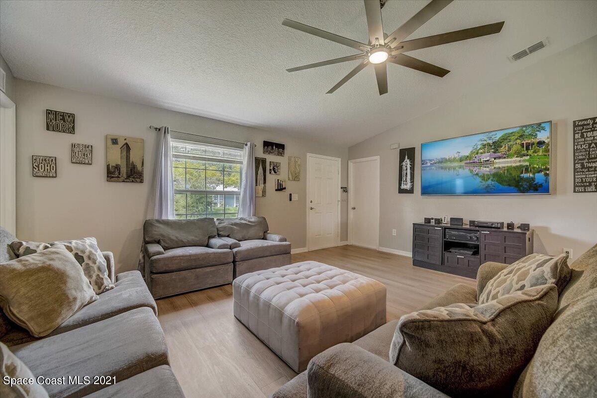 1459 Saxony Road Southwest Palm Bay, FL 32908 - Photo 8 of 38 a living room with furniture and a flat screen tv